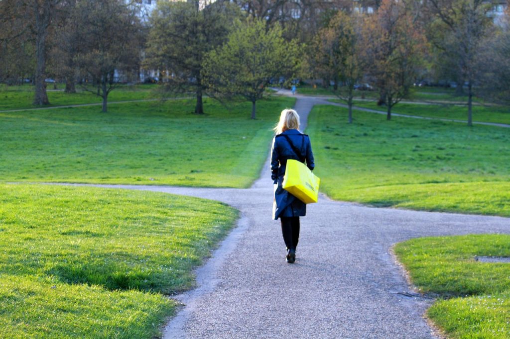 woman walks down a path that has many directions