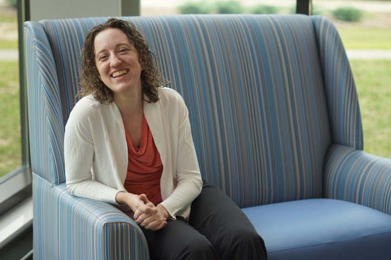 Shelley Etto sitting on chair in front of window